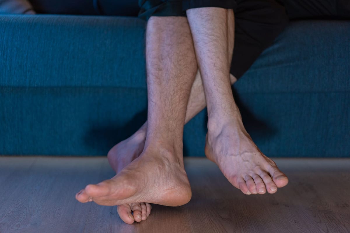 Bare legs crossed at the ankle, resting against a blue sofa